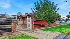 A residential property with a gated entrance, a satellite dish, and a large tree. - Well-Located St Albans Stay with Fully Equipped Kitchen (Saint Albans)