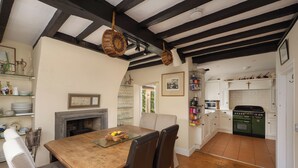 A dining area with a wooden table, chairs, and a fireplace.