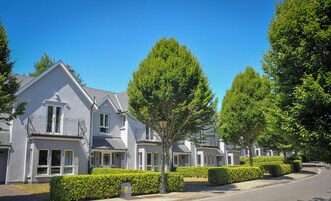 A row of modern houses with a uniform architectural style, featuring large windows and a balcony on the second floor.