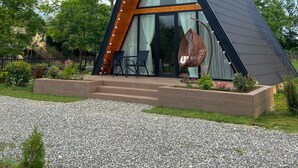 A modern, triangular-shaped building with a sloped roof, large glass windows, and a wooden interior.