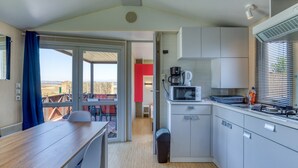 A compact kitchen with a microwave, coffee maker, and a view through the door.
