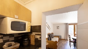 A kitchen with a microwave, coffee maker, and a basket on the counter. - “Le Skieur” Apartment with Mountain View, Balcony, and Wi-Fi (Aillon-le-Jeune)