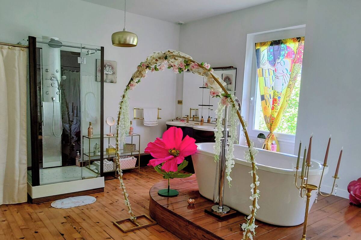 A bathroom with a glass shower enclosure, a bathtub, and a vanity with a mirror.