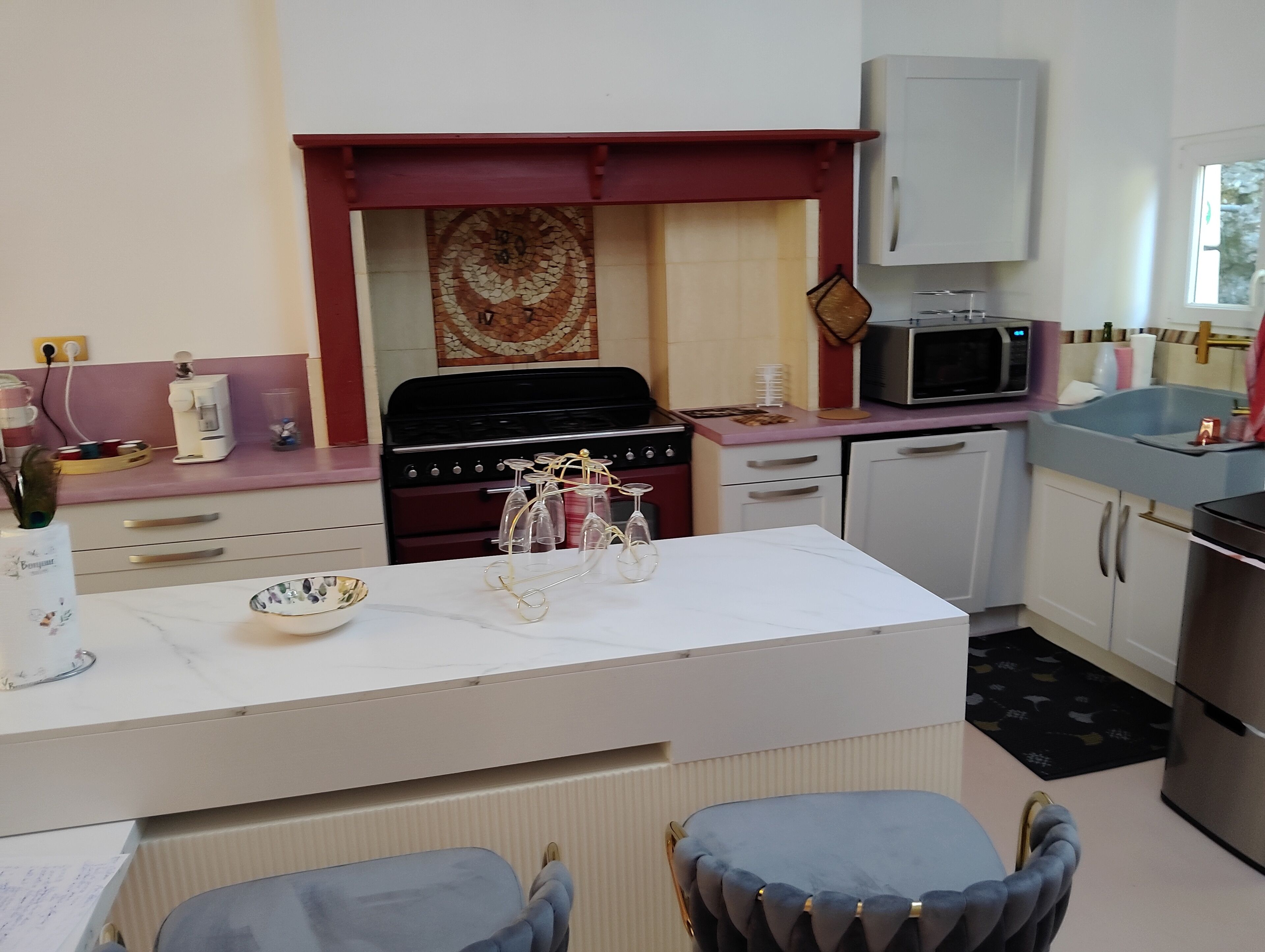 A kitchen with a stove, microwave, and cabinets. There is a dining table with chairs.