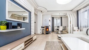 Una sala de estar moderna con chimenea, comedor y un espejo grande en la pared.