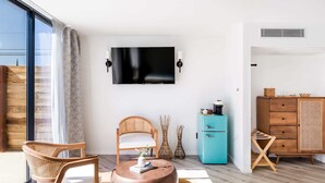Un salón moderno con un televisor grande, muebles de madera y un armario azul.