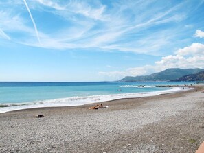 A pebble beach with a clear sky and distant mountains. - Beautiful private villa for 4 people with WIFI, terrace and pets allowed (Ventimiglia)
