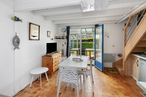 Una cocina compacta con comedor, televisor y escalera.