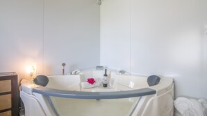 A modern bathroom with a bathtub, a towel, and a bottle of shampoo. - Apartment 'El Encanto' with Mountain View, Private Pool and Wi-Fi (Villarrasa)
