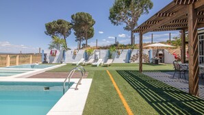 A pool area with a wooden pergola, artificial grass, and lounge chairs. - Apartment 'El Encanto' with Mountain View, Private Pool and Wi-Fi (Villarrasa)