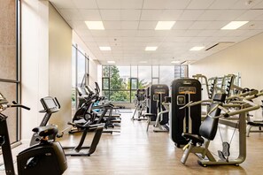 Ein Fitnessstudio mit Laufbändern, Crosstrainern und Kraftgeräten.