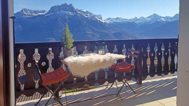 A balcony with a view of snow-capped mountains, a potted plant, and two chairs. - Fully renovated duplex with exceptional view of the MONT BLANC (Cordon)