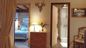 A wooden interior with a bed, a dresser, a lamp, and a shower area. - Fully renovated duplex with exceptional view of the MONT BLANC (Cordon)