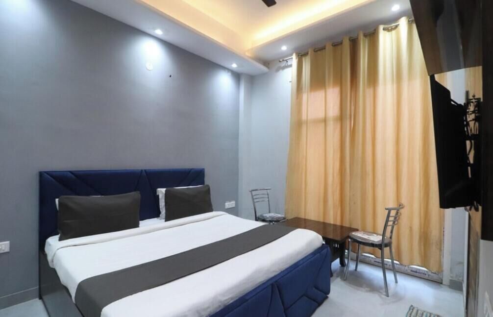 Una camera d'albergo con un letto, un tavolino e una sedia.