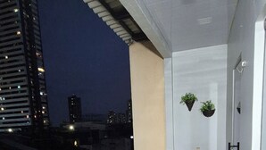 A corridor with a tiled floor, a sink, and hanging plants. - Apartment in a prime location, quiet and family-friendly environment, close to everything. (Belém)