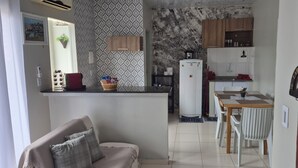 A compact kitchen with a refrigerator, stove, and dining area. - Apartment in a prime location, quiet and family-friendly environment, close to everything. (Belém)