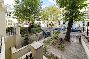A residential street with trees, a bicycle, and parked cars. - Notting Hill Bohemian Apartment (London)