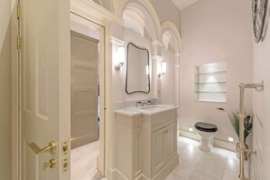 Ein Badezimmer mit Waschtisch, Toilette und Spiegel.