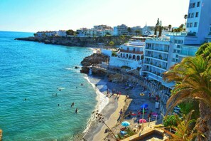 A coastal hotel with a beach, clear blue sea, and a rocky shoreline. - Sunny Studio in Nerja Center with Balcony close to Beach (Nerja)