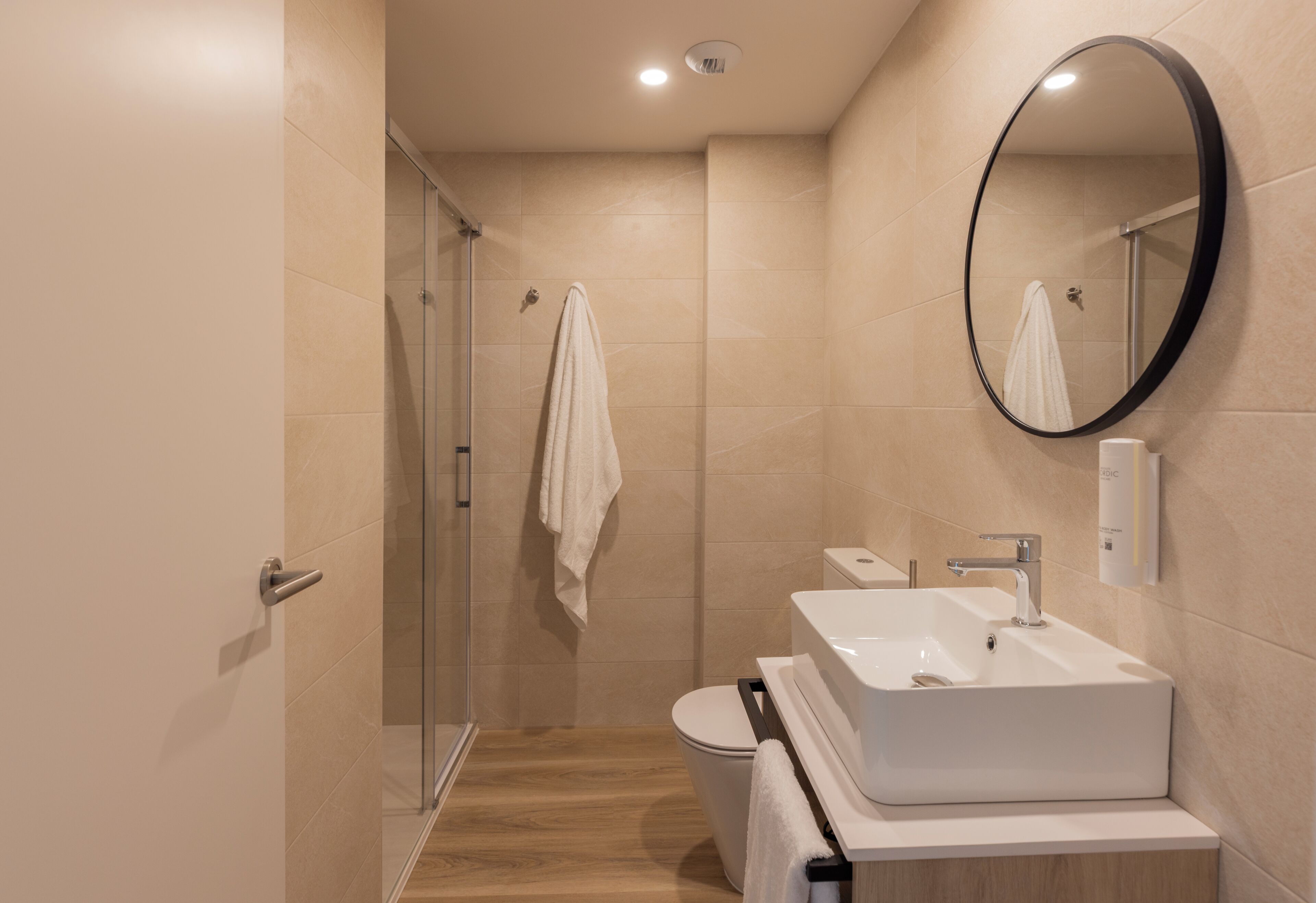 Estudio luminoso | Badkamer | Een douche, een haardroger, handdoeken, zeep