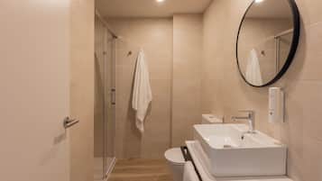 Estudio luminoso | Badkamer | Een douche, een haardroger, handdoeken, zeep