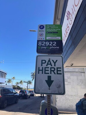 Een parkeersbord met een 'Betalen hier'-symbool en de optie PayByPhone, dat de beschikbare betaalmethoden aangeeft.