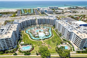 Ein Resort mit mehreren Schwimmbecken, einem Strand und einem Steg.