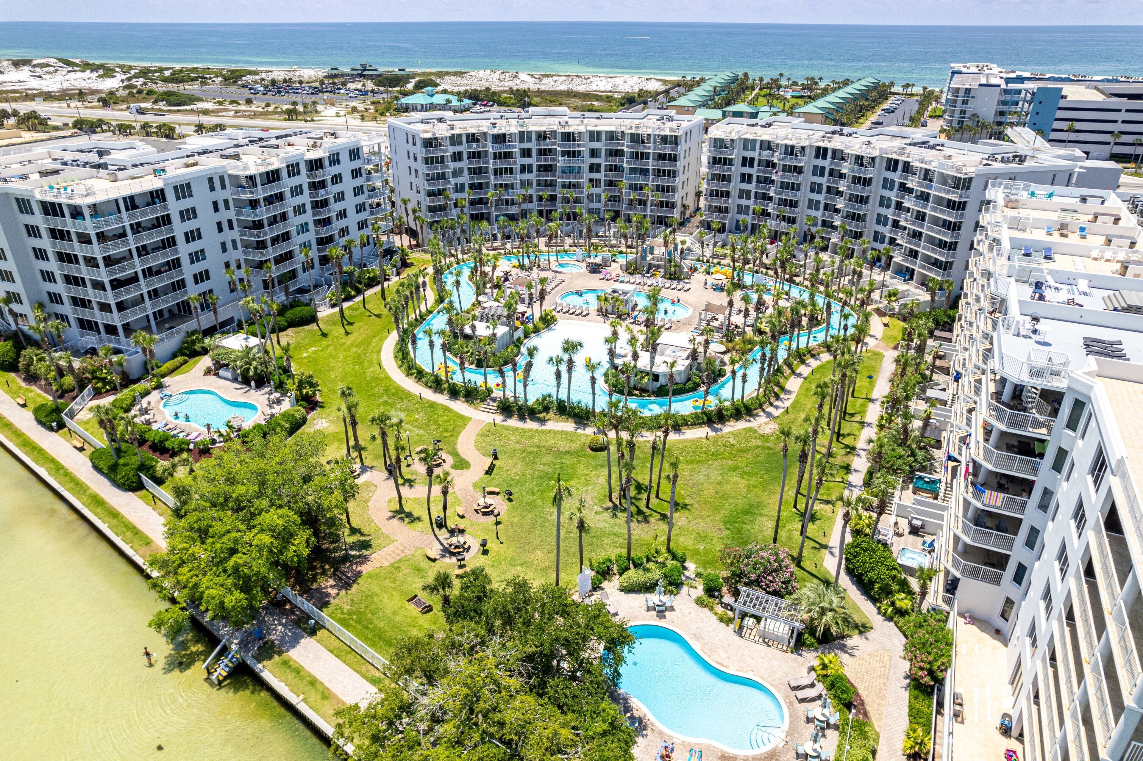 Een resort met meerdere gebouwen, een centraal gelegen zwembad en een strand.