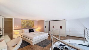 A modern hotel room with a bed, bedside table, lamp, and a view of the balcony. - Bright Sliema Coastal Apartment with Sea Terrace (Tas-Sliema)