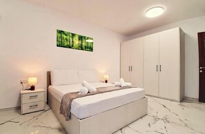 Ein Schlafzimmer mit Bett, Nachttischen, einem Kleiderschrank und einem Wandbild.
