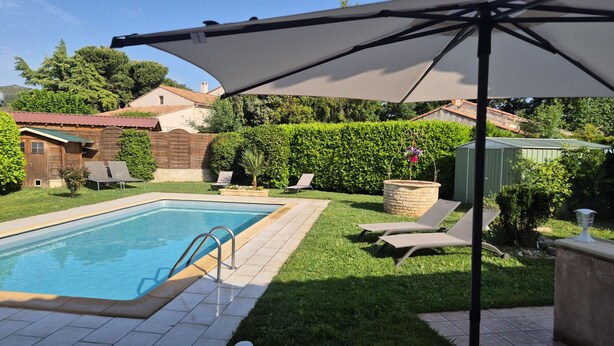 A swimming pool with a ladder, lounge chairs, and a covered patio area. - 6 guests house with private pool in Eyguières Alpilles (Eyguières)