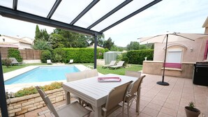 A covered patio with a pool, outdoor furniture, and a view of the backyard. - 6 guests house with private pool in Eyguières Alpilles (Eyguières)