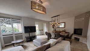 A modern living room with a sofa, TV, dining table, and fireplace. - 6 guests house with private pool in Eyguières Alpilles (Eyguières)