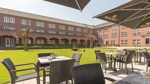 A courtyard with outdoor seating, a brick building, and a Swincoln's logo. - Stay in the Heart of Nature With Comfort All Around! Onsite Dining, Free Parking (Deurne)