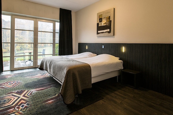 Drift off beside wide doors framing peaceful nature views.