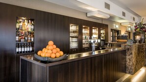 A bar area with a dark wood finish, a bowl of oranges, and shelves of liquor bottles. - A Great Place to Unwind and Explore! Close to Valkhof Museum! (Berg en Dal)