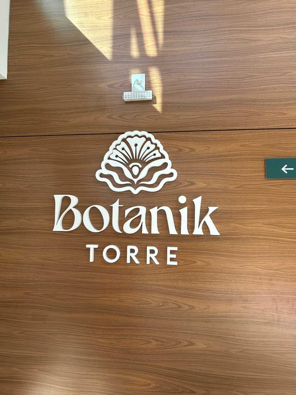 A wooden door with the logo 'Botanik TORRE' and a directional arrow.