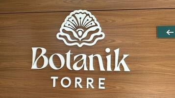 A wooden door with the logo 'Botanik TORRE' and a directional arrow.