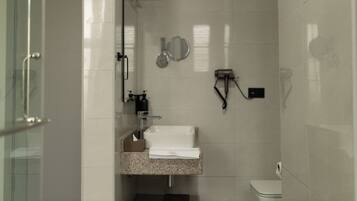Studio | Badkamer | Een douche, een haardroger, pantoffels, handdoeken