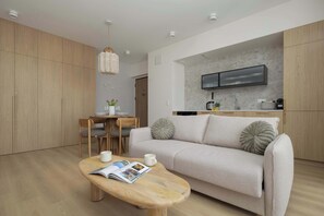 A modern living room with a sofa, coffee table, and dining area. - Modern Apartment Near Downtown | Air Conditioning (Warszawa)