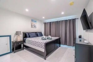 A bedroom with a bed, a nightstand, a TV, and a cabinet. - The Purple Pelican~Beachfront w/Ocean Balcony~#4 (Fort Lauderdale)
