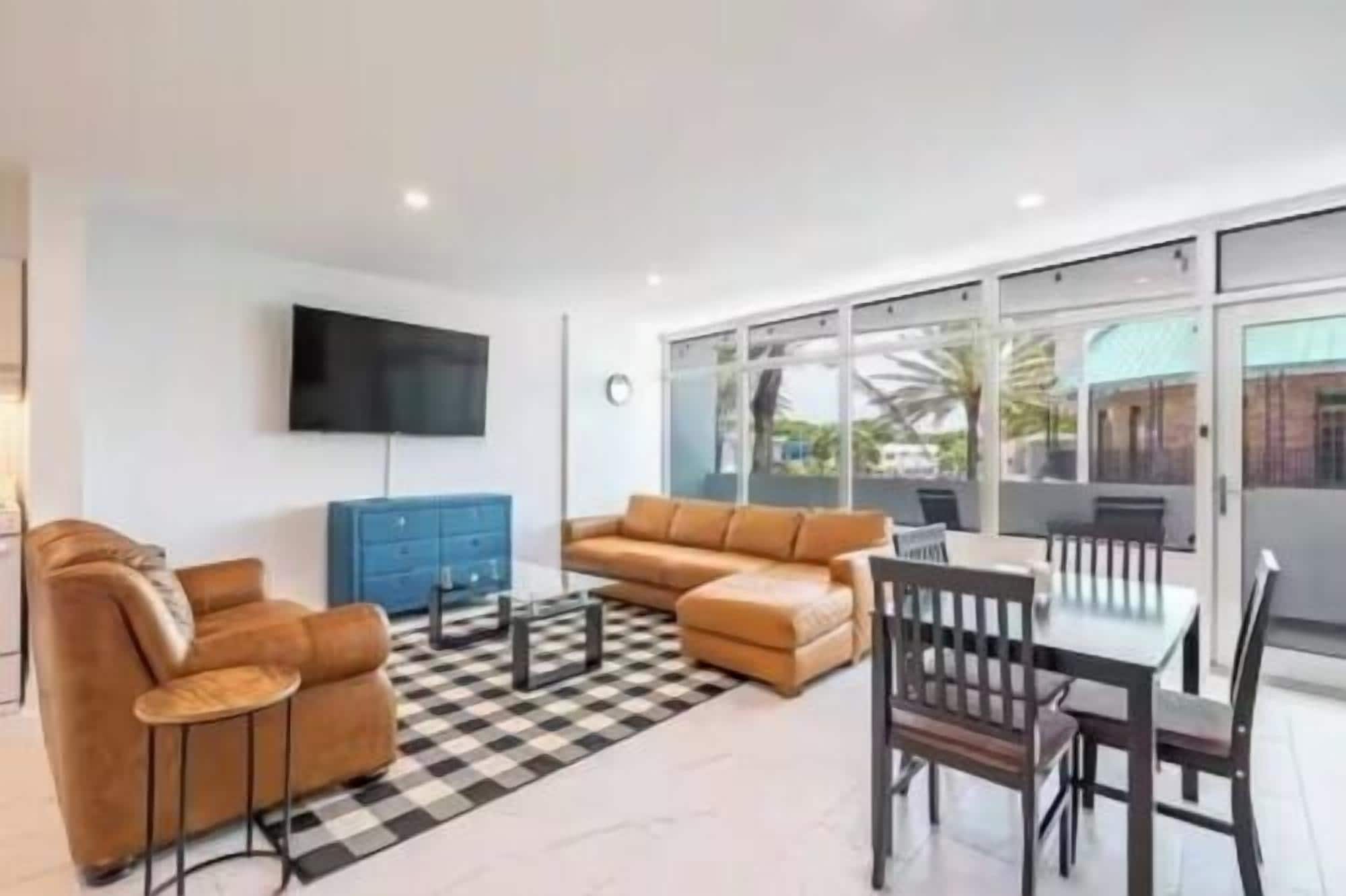 A modern living room with a sofa, coffee table, and dining table.