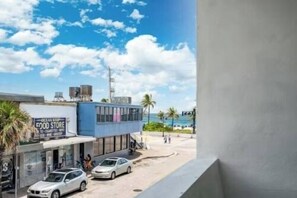 Une vue sur la côte, avec une épicerie, un bâtiment à la façade bleue et un ciel dégagé.