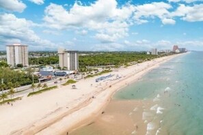 Un hôtel situé sur la côte, avec vue sur la plage, composé de plusieurs bâtiments et bénéficiant d’un ciel dégagé.