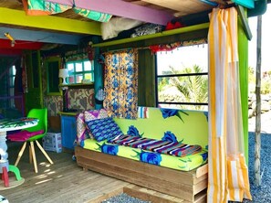 Una habitación colorida con una cama de madera, una silla verde y una mesa con una lámpara.