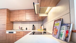 Eine moderne Küche mit Holzschränken, einer weißen Arbeitsplatte und einem eingebauten Backofen.