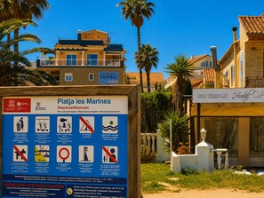 A signboard with beach protection information, a residential building, and a bar terrace. - Ap2214 in Denia With 2 Bedrooms and 2 Bathrooms (Denia)