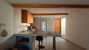 Una cocina moderna con vigas de madera, un taburete de bar y una isla grande.