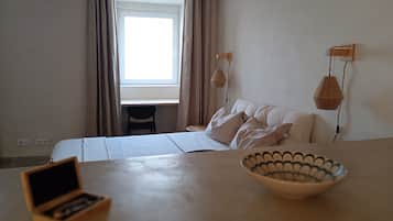 Un dormitorio con cama, escritorio, silla, un cuenco y una lámpara colgante.