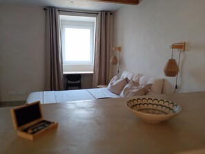 A bedroom with a bed, a desk, a chair, a bowl, and a hanging light fixture. - Murfacem (Almada)